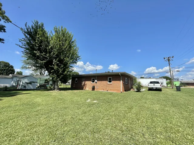 a view of a house with a yard and sitting area