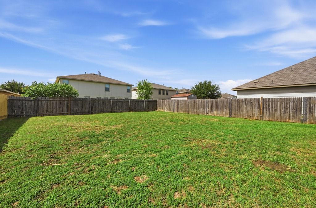 209 Noddy Road Buda, TX 78610 - Photo 25 of 27 A fully enclosed grass yard provides a versatile outdoor space with privacy fencing.