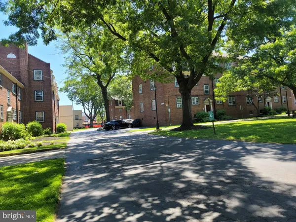 a view of a street with a building and trees in the background