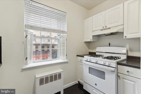 a kitchen with stainless steel appliances white cabinets and a stove