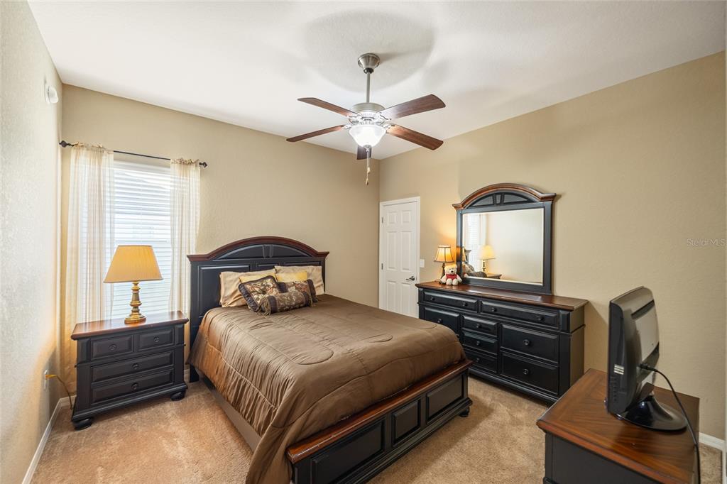 2836 Whitney Street Lakeland, FL 33813 - Photo 27 of 44 a bedroom with a bed and dresser with chandelier