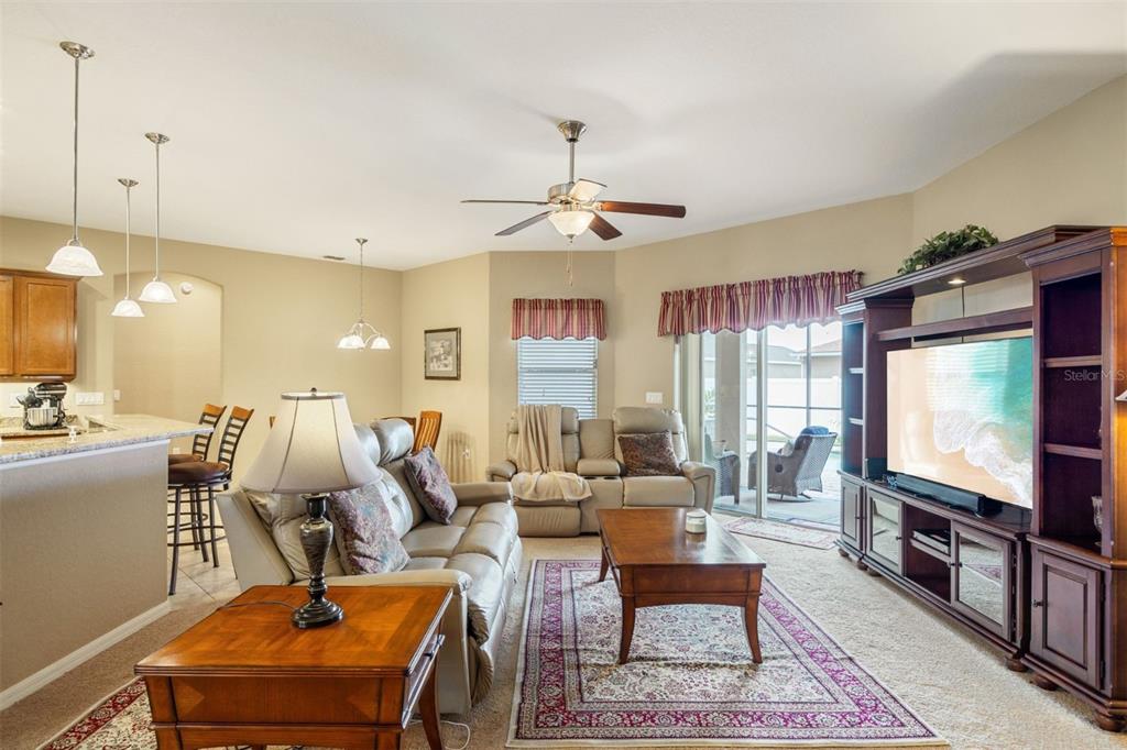 2836 Whitney Street Lakeland, FL 33813 - Photo 6 of 44 a living room with furniture a flat screen tv and kitchen view