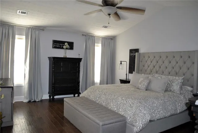 a bathroom with a granite countertop toilet sink and mirror