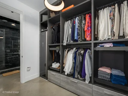 a view of walk in closet with clothes and shoes