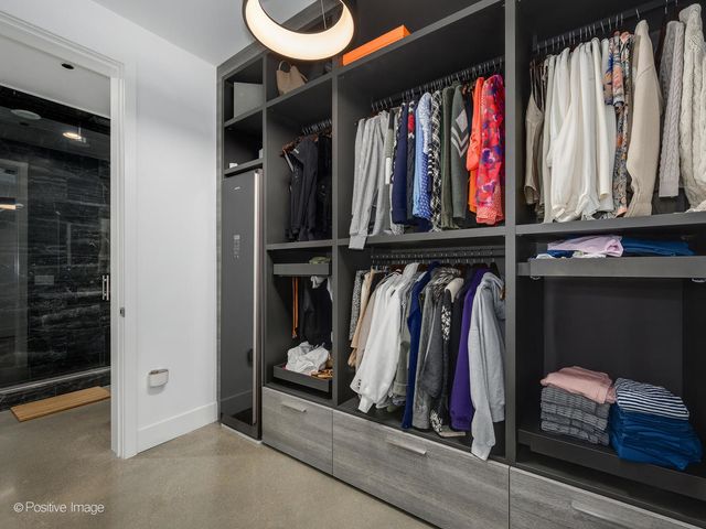 a view of walk in closet with clothes and shoes