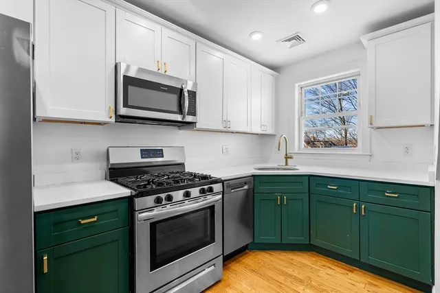 a kitchen with stainless steel appliances white cabinets and stove