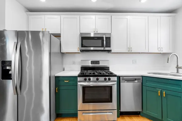 a kitchen with stainless steel appliances granite countertop a stove a refrigerator and a sink