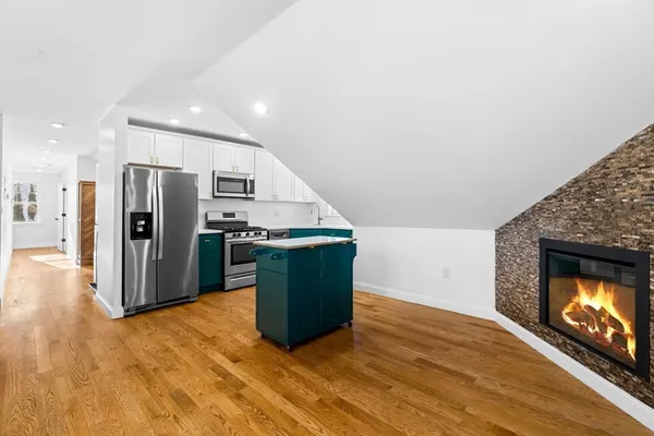 a view of kitchen with stainless steel appliances kitchen island wooden floor and living room