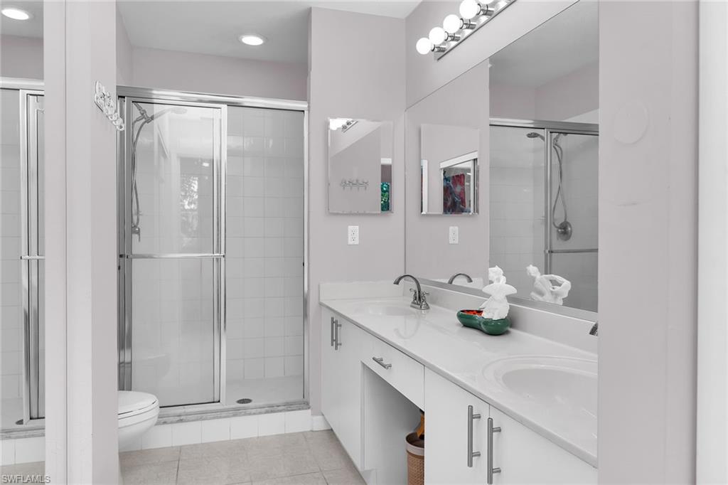 8345 Whisper Trace Way, Unit 102 Naples, FL 34114 - Photo 11 of 25 a bathroom with a double vanity sink mirror and shower