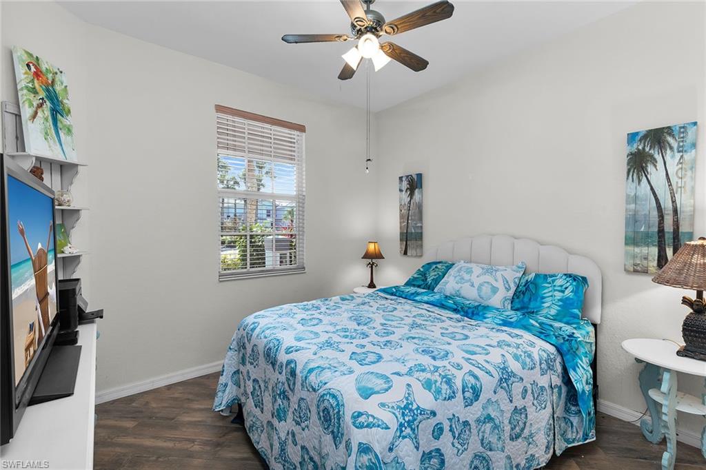 8345 Whisper Trace Way, Unit 102 Naples, FL 34114 - Photo 12 of 25 a bedroom with a bed and a chandelier
