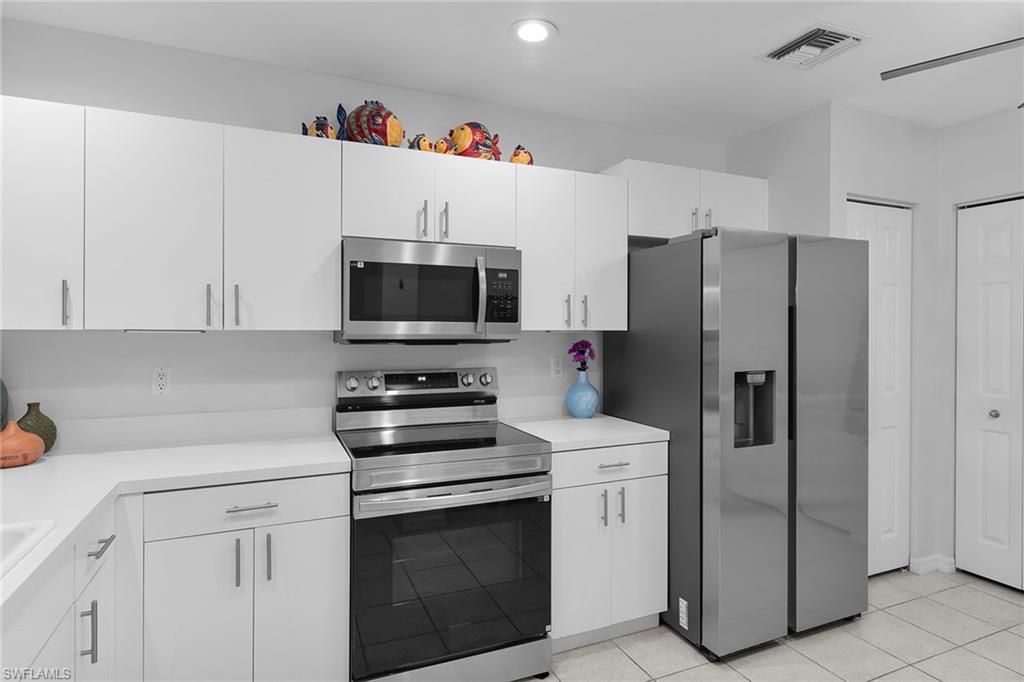 8345 Whisper Trace Way, Unit 102 Naples, FL 34114 - Photo 2 of 25 a kitchen with stainless steel appliances a refrigerator stove and white cabinets