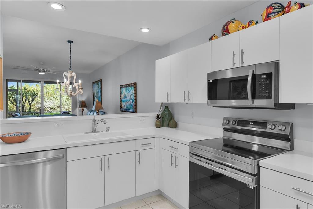 8345 Whisper Trace Way, Unit 102 Naples, FL 34114 - Photo 4 of 25 a kitchen with stainless steel appliances white cabinets and a sink