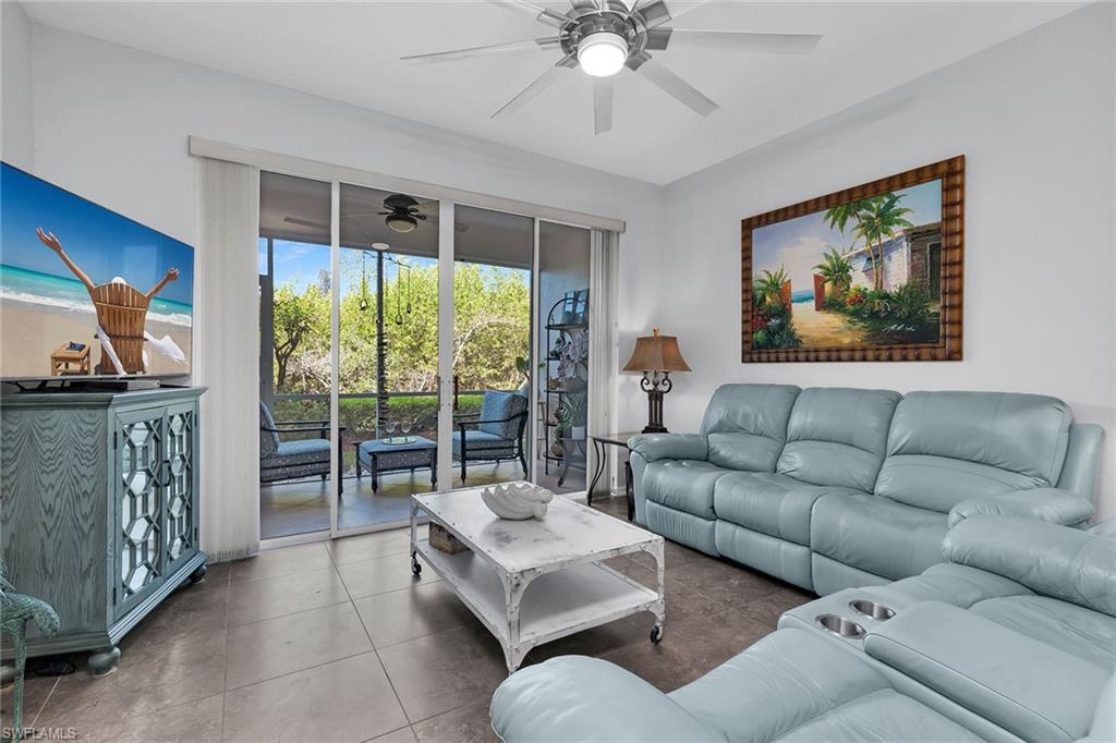 8345 Whisper Trace Way, Unit 102 Naples, FL 34114 - Photo 8 of 25 a living room with furniture and a flat screen tv