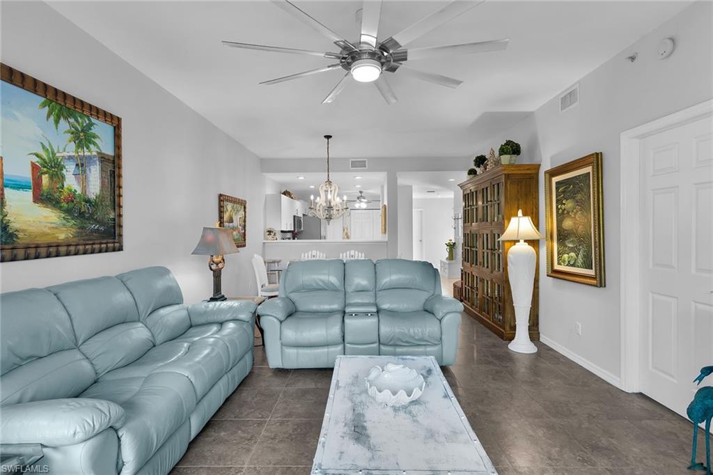 8345 Whisper Trace Way, Unit 102 Naples, FL 34114 - Photo 9 of 25 a living room with furniture and a chandelier