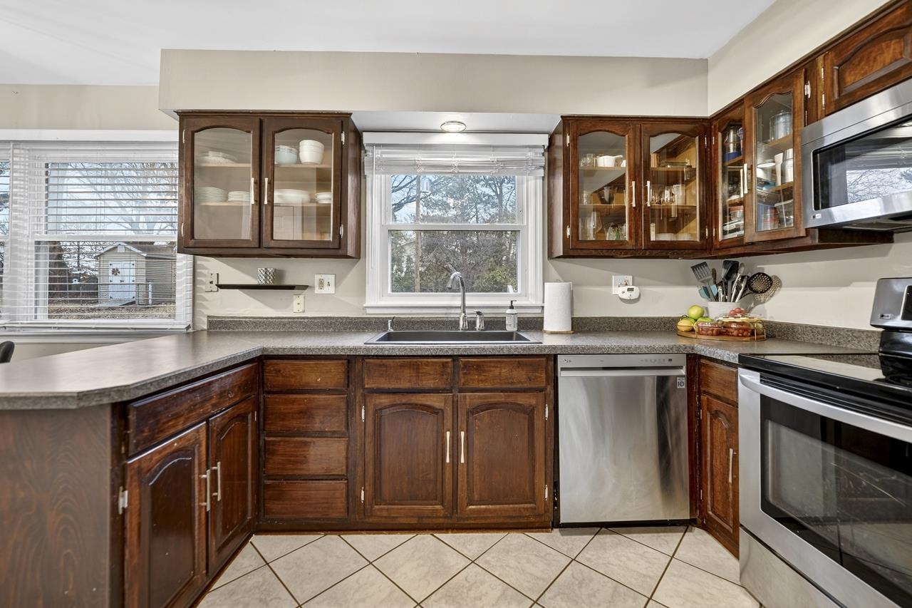 4966 Brigadoon Road Rockford, IL 61107 - Photo 13 of 40 a kitchen with stainless steel appliances granite countertop a sink stove and cabinets
