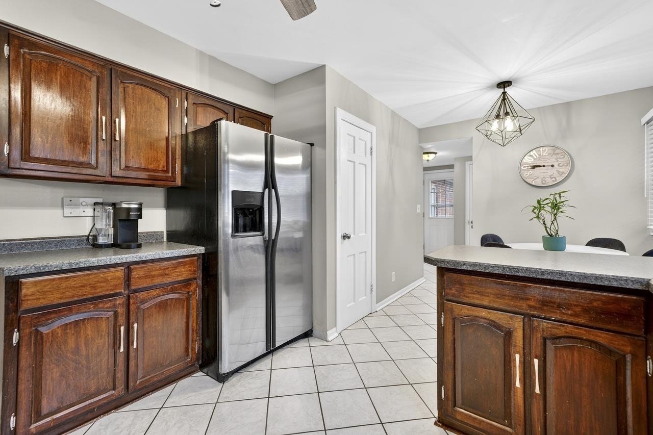4966 Brigadoon Road Rockford, IL 61107 - Photo 14 of 40 a kitchen with stainless steel appliances granite countertop a refrigerator a sink dishwasher and wooden cabinets with wooden floor