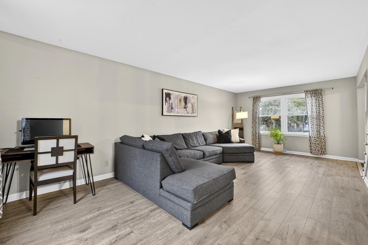 4966 Brigadoon Road Rockford, IL 61107 - Photo 6 of 40 a living room with furniture and a flat screen tv with wooden floor