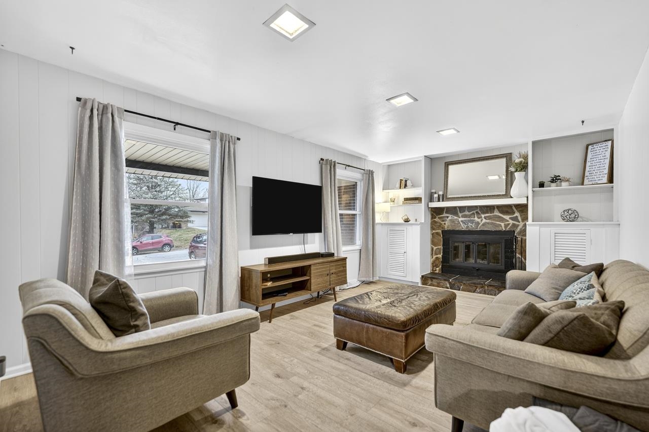 4966 Brigadoon Road Rockford, IL 61107 - Photo 10 of 40 a living room with furniture a flat screen tv and a fireplace