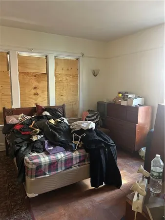 a black leather couch sitting in a room next to a window