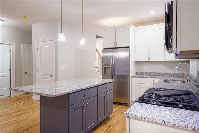 a kitchen with stainless steel appliances granite countertop a stove a refrigerator and a sink