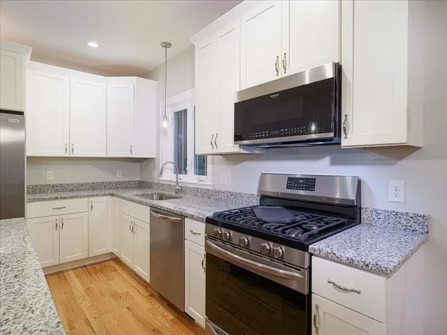 a kitchen with granite countertop a stove and a sink