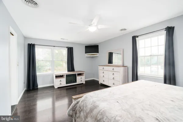 a bedroom with a large bed and a flat tv screen on dresser