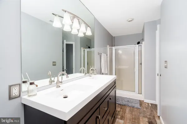 a bathroom with a sink mirror and a shower