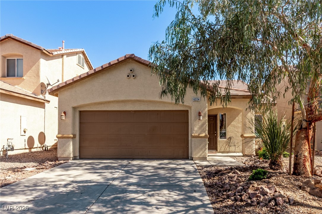 6224 Boulder Rise Street Las Vegas, NV 89115 - Photo 1 of 26 Mediterranean / spanish-style house featuring driveway, a tiled roof, stucco siding, and a garage