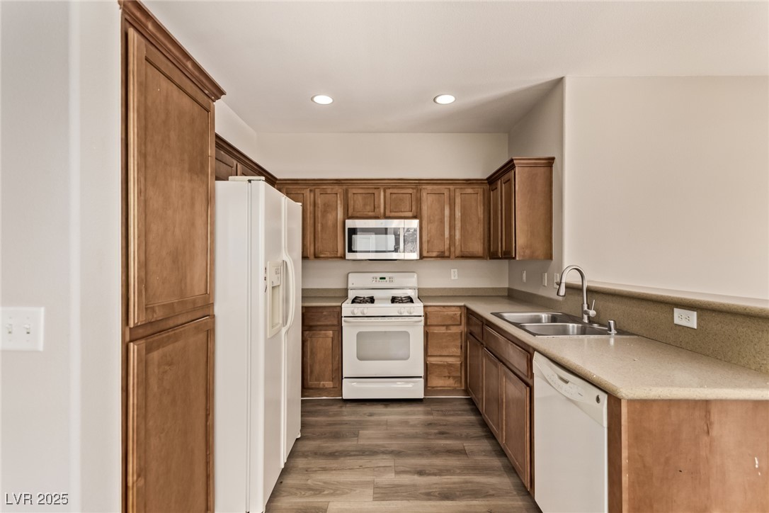 6224 Boulder Rise Street Las Vegas, NV 89115 - Photo 12 of 26 Kitchen with white appliances, dark wood-style floors, brown cabinetry, light countertops, and recessed lighting