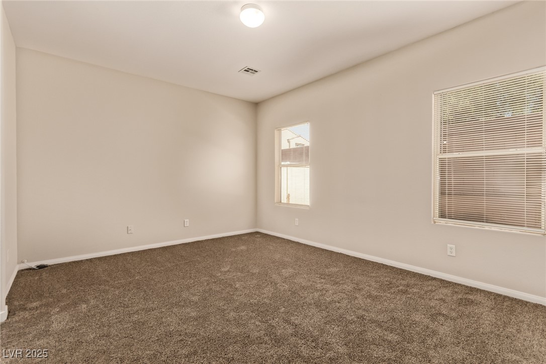 6224 Boulder Rise Street Las Vegas, NV 89115 - Photo 16 of 26 Spare room with dark colored carpet and baseboards