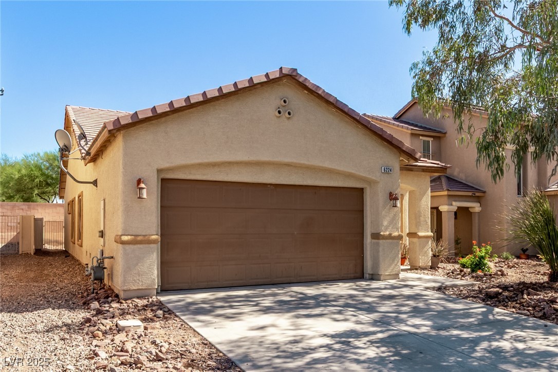 6224 Boulder Rise Street Las Vegas, NV 89115 - Photo 2 of 26 View of front of property with a tiled roof, a garage, driveway, and stucco siding