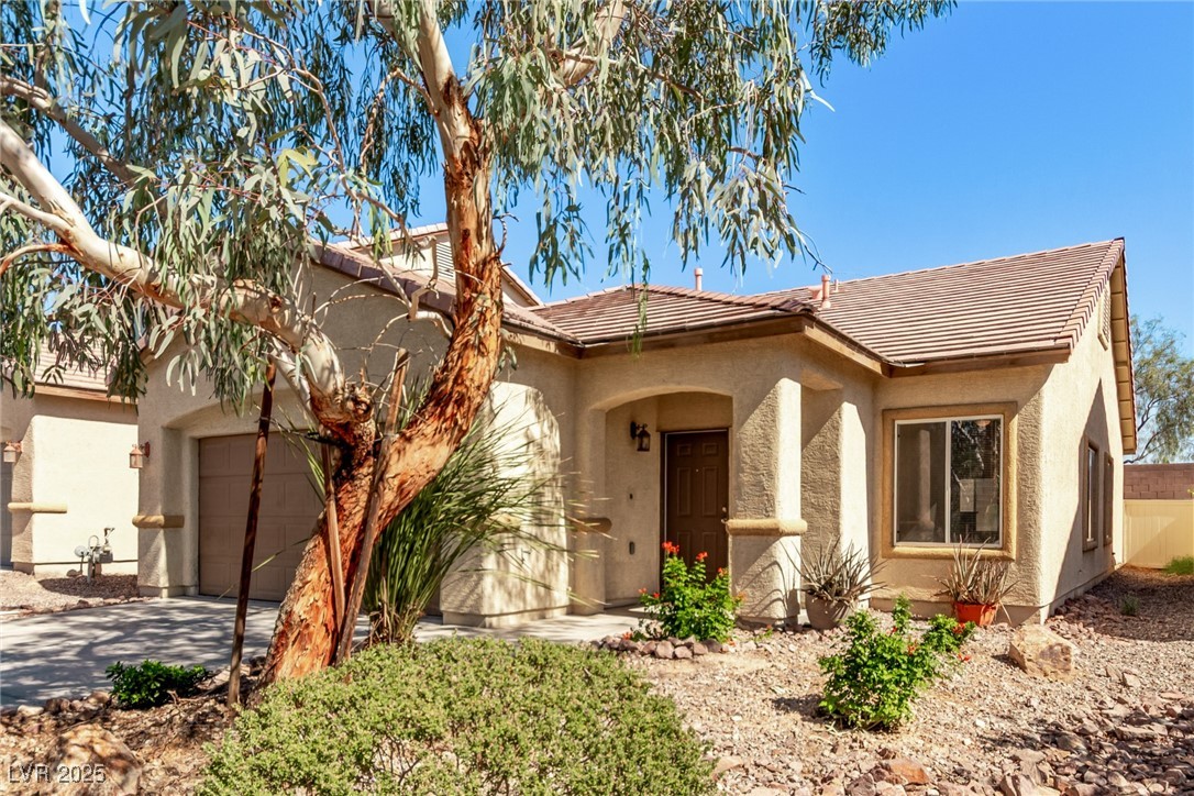 6224 Boulder Rise Street Las Vegas, NV 89115 - Photo 3 of 26 View of front of home featuring a tile roof, stucco siding, concrete driveway, and an attached garage