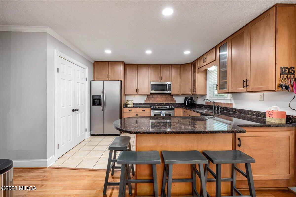 222 Red Oak Road Byron, GA 31008 - Photo 8 of 38 a kitchen with stainless steel appliances granite countertop a stove a sink a refrigerator white cabinets and wooden floor