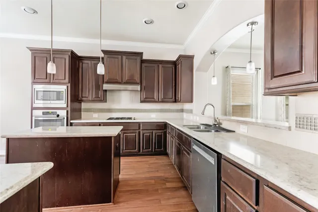 a kitchen with stainless steel appliances granite countertop a sink a stove and a refrigerator
