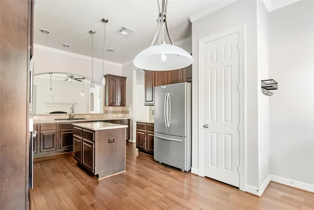 a kitchen with stainless steel appliances a stove a refrigerator and a chandelier