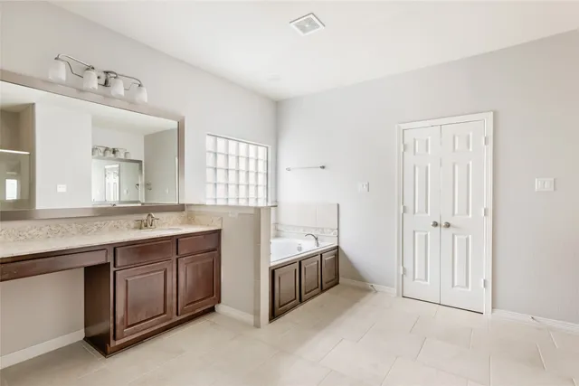 a spacious bathroom with a granite countertop sink and a mirror