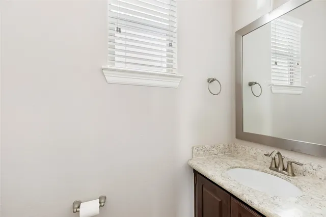 a bathroom with a granite countertop sink and a vanity