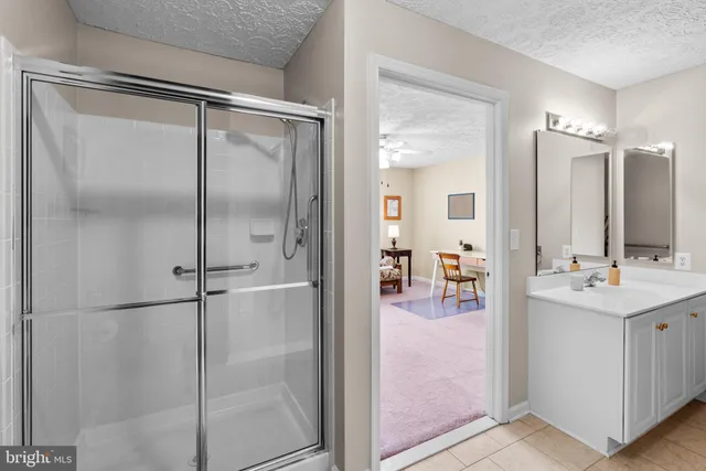 a bathroom with a shower sink and mirror