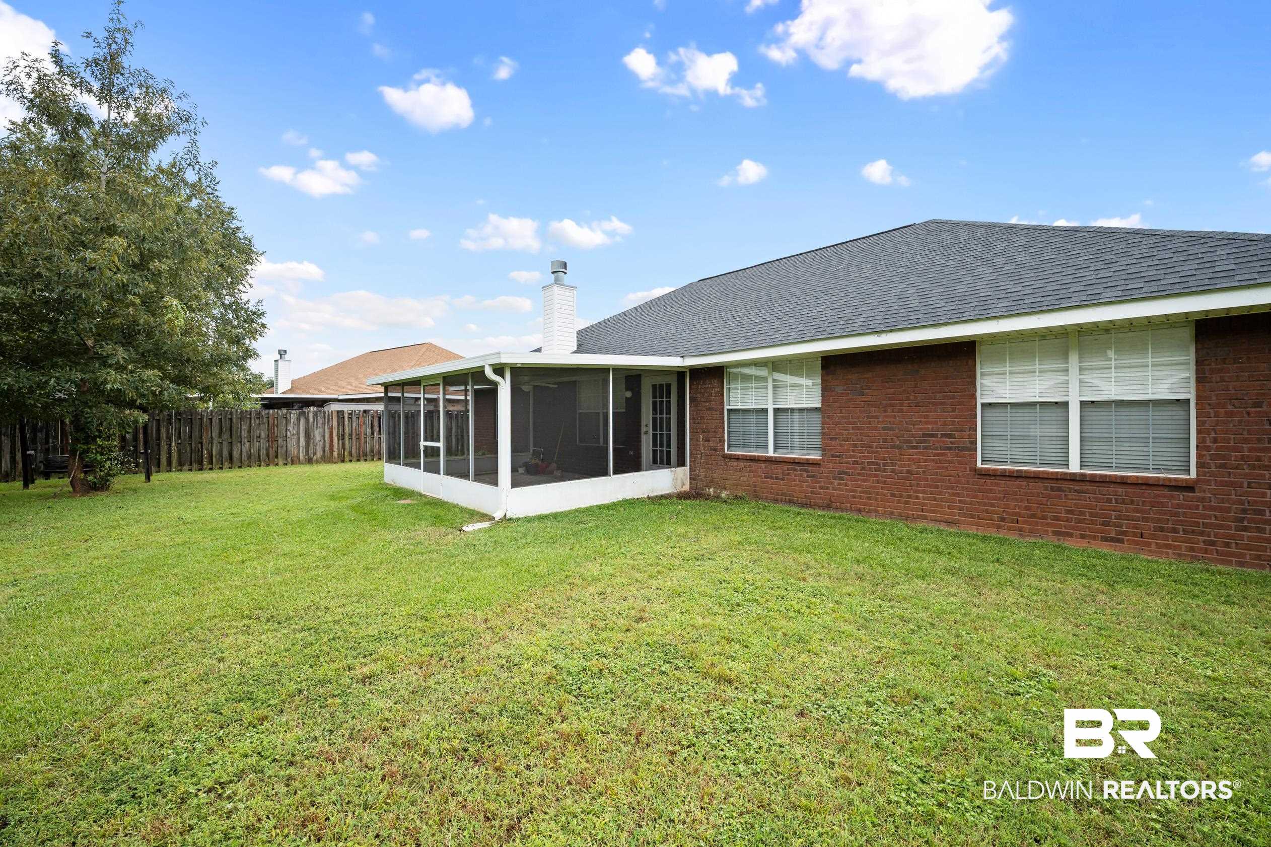 306 Monteith Oaks Drive Foley, AL 36535 - Photo 29 of 38 Back of house featuring a sunroom, a chimney, a shingled roof, brick siding, and a fenced backyard