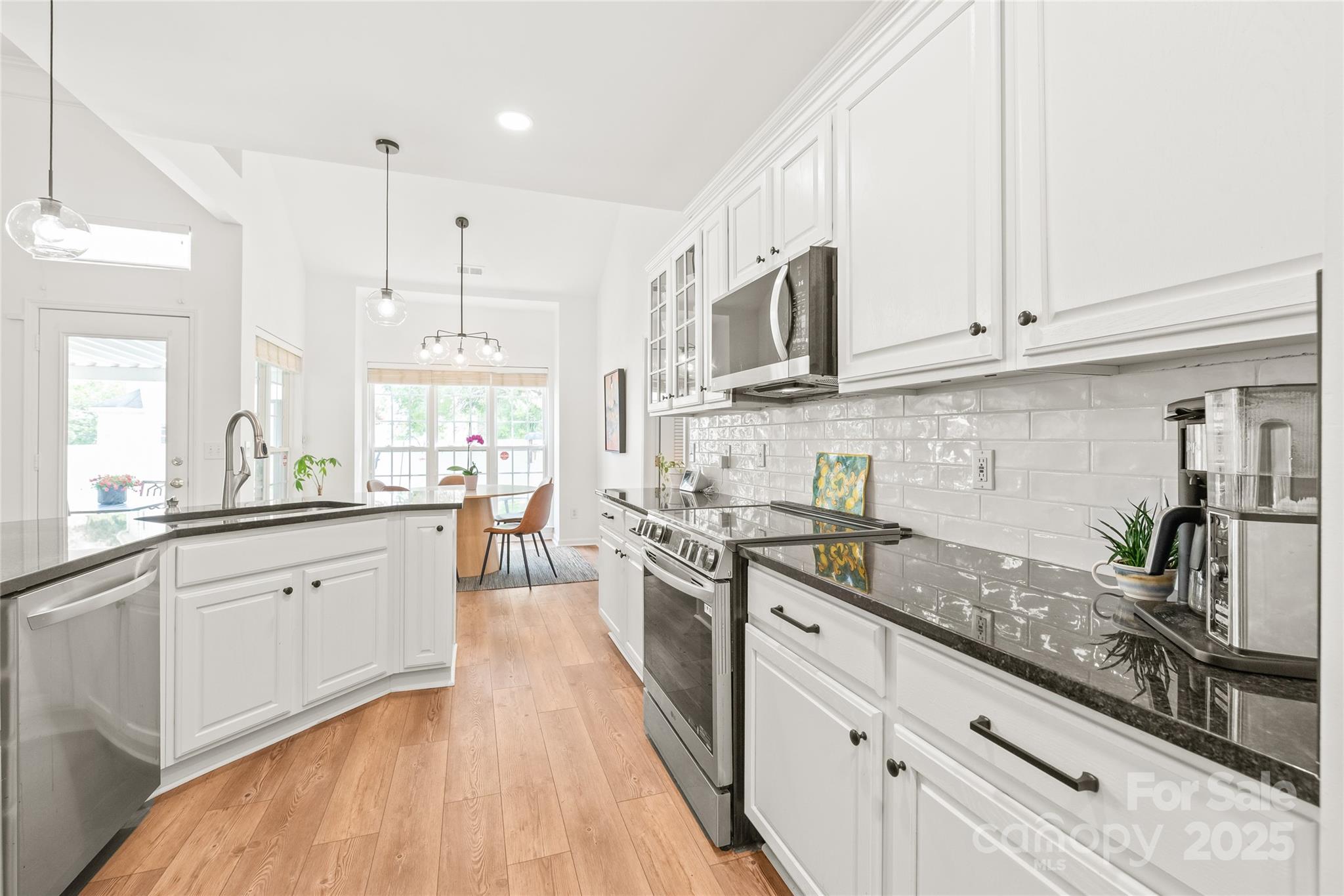 502 Roxanne Court Northwest Concord, NC 28027 - Photo 17 of 40 a large kitchen with stainless steel appliances granite countertop a stove a sink and white cabinets