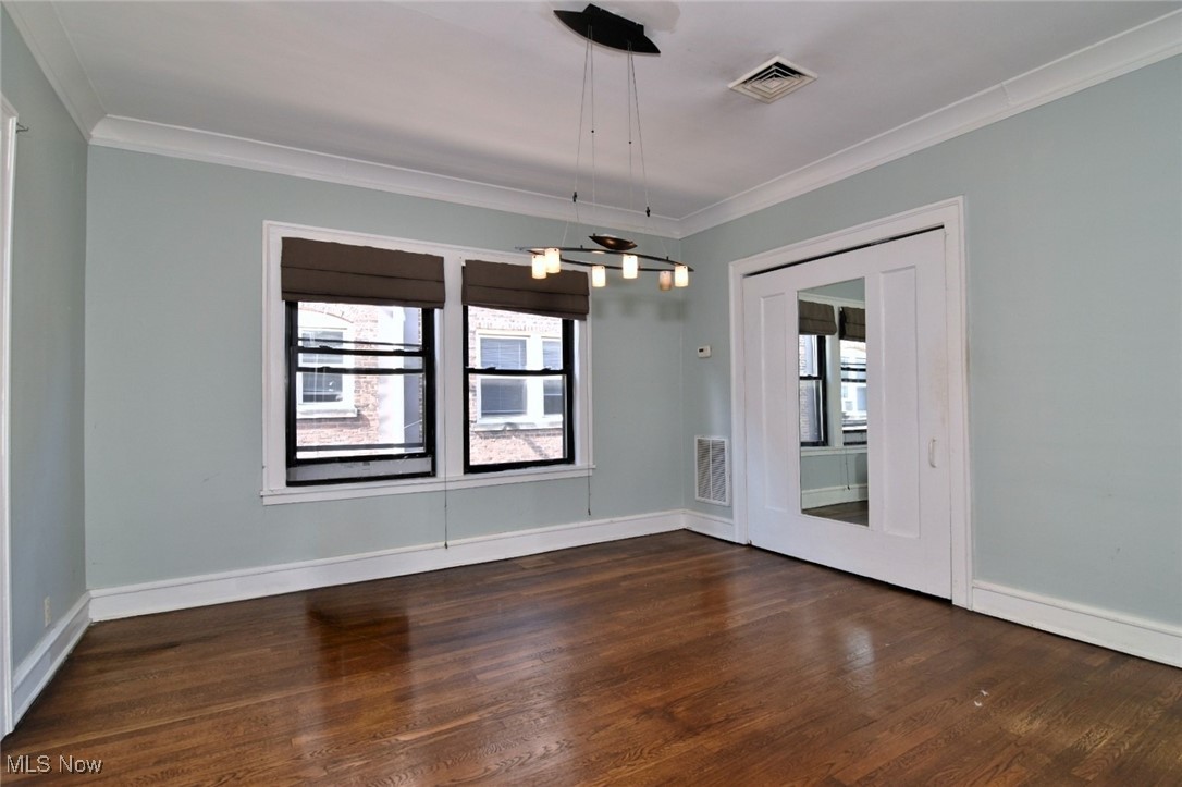 2469 Overlook Road, Unit 8 Cleveland, OH 44106 - Photo 11 of 24 Empty room featuring crown molding, a chandelier, and dark wood-style flooring