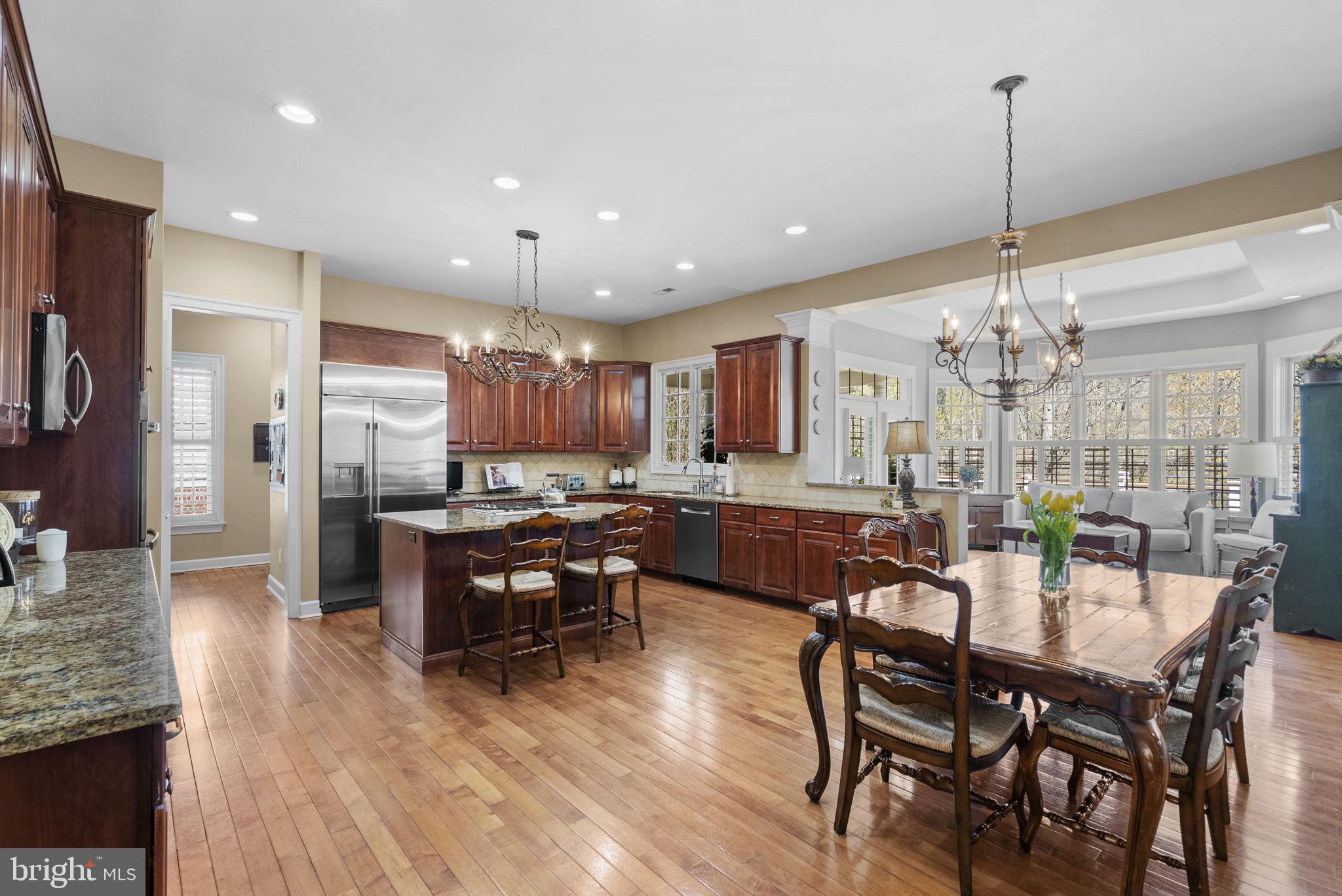 17516 Ashton Green Drive Sandy Spring, MD 20860 - Photo 19 of 60 a kitchen with kitchen island a dining table chairs stainless steel appliances and cabinets