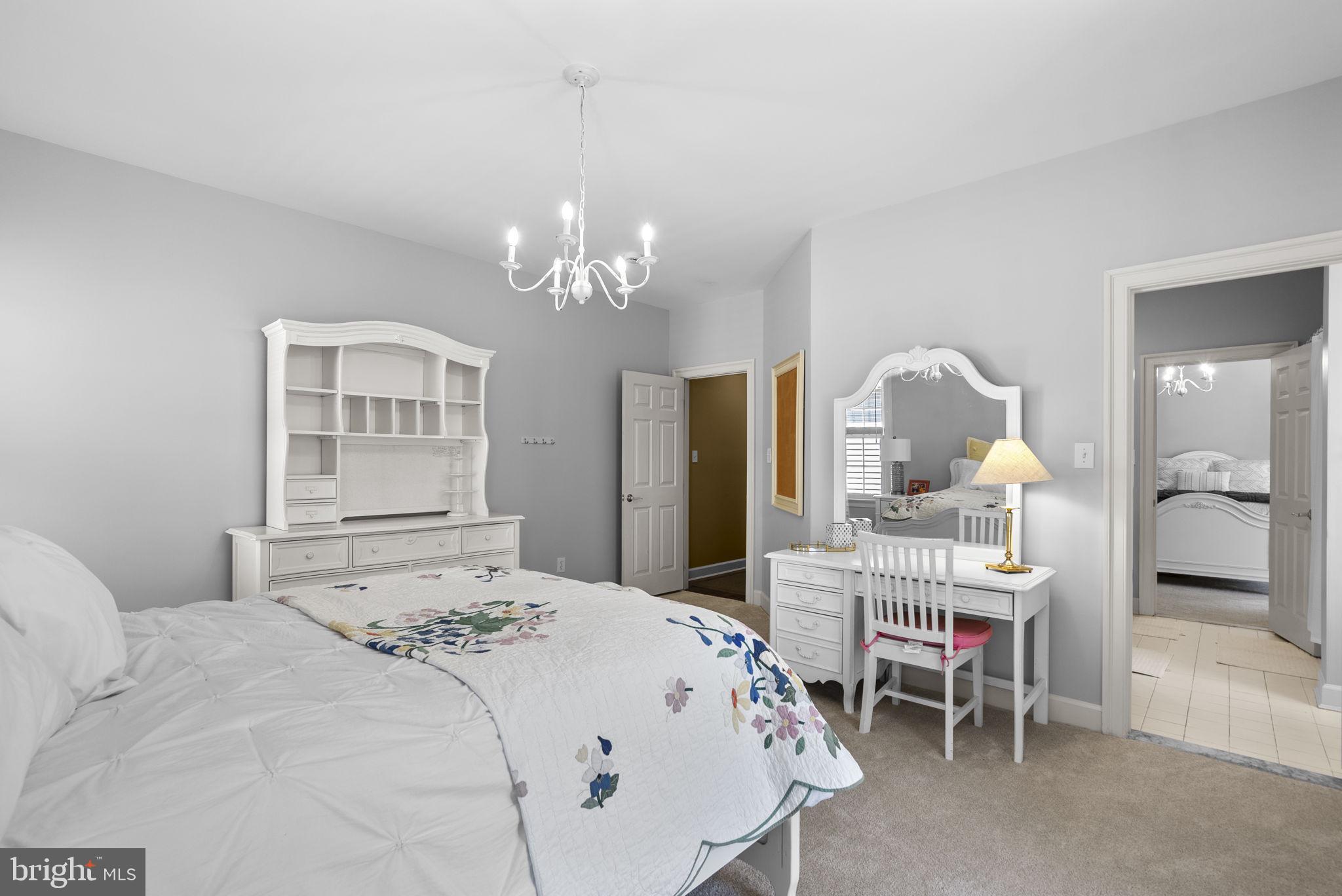 17516 Ashton Green Drive Sandy Spring, MD 20860 - Photo 50 of 60 a bedroom with a bed mirror and a chandelier