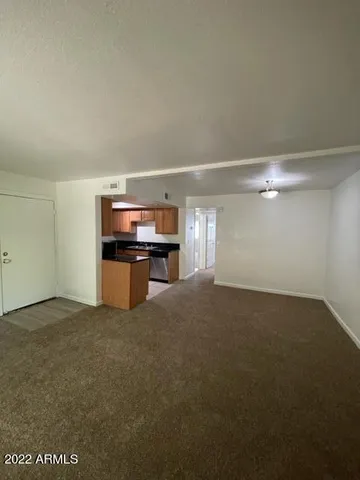 a view of an empty room with kitchen