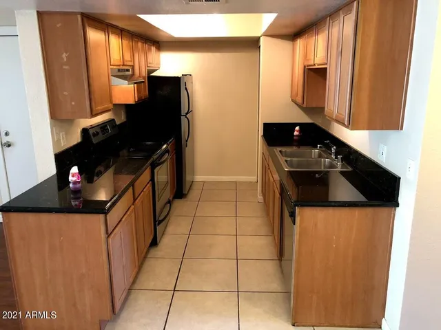 a kitchen with granite countertop a refrigerator and a stove