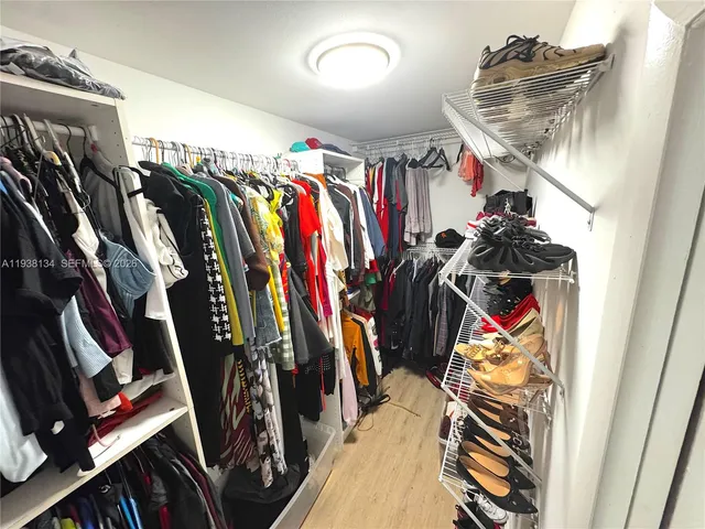 a view of walk in closet with clothes