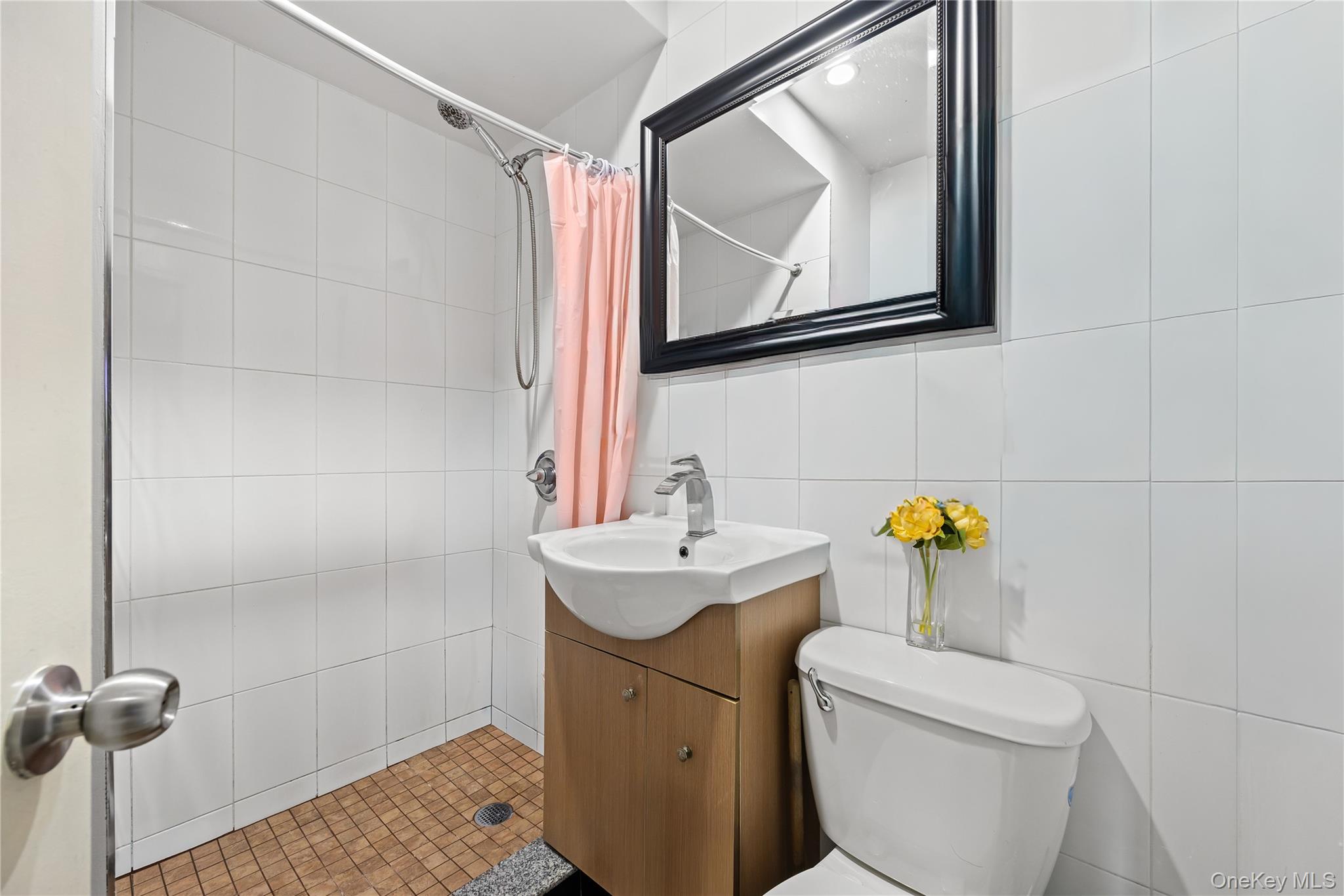 106-07 Northern Boulevard, Unit 5B Queens, NY 11368 - Photo 12 of 18 a bathroom with a toilet sink and mirror