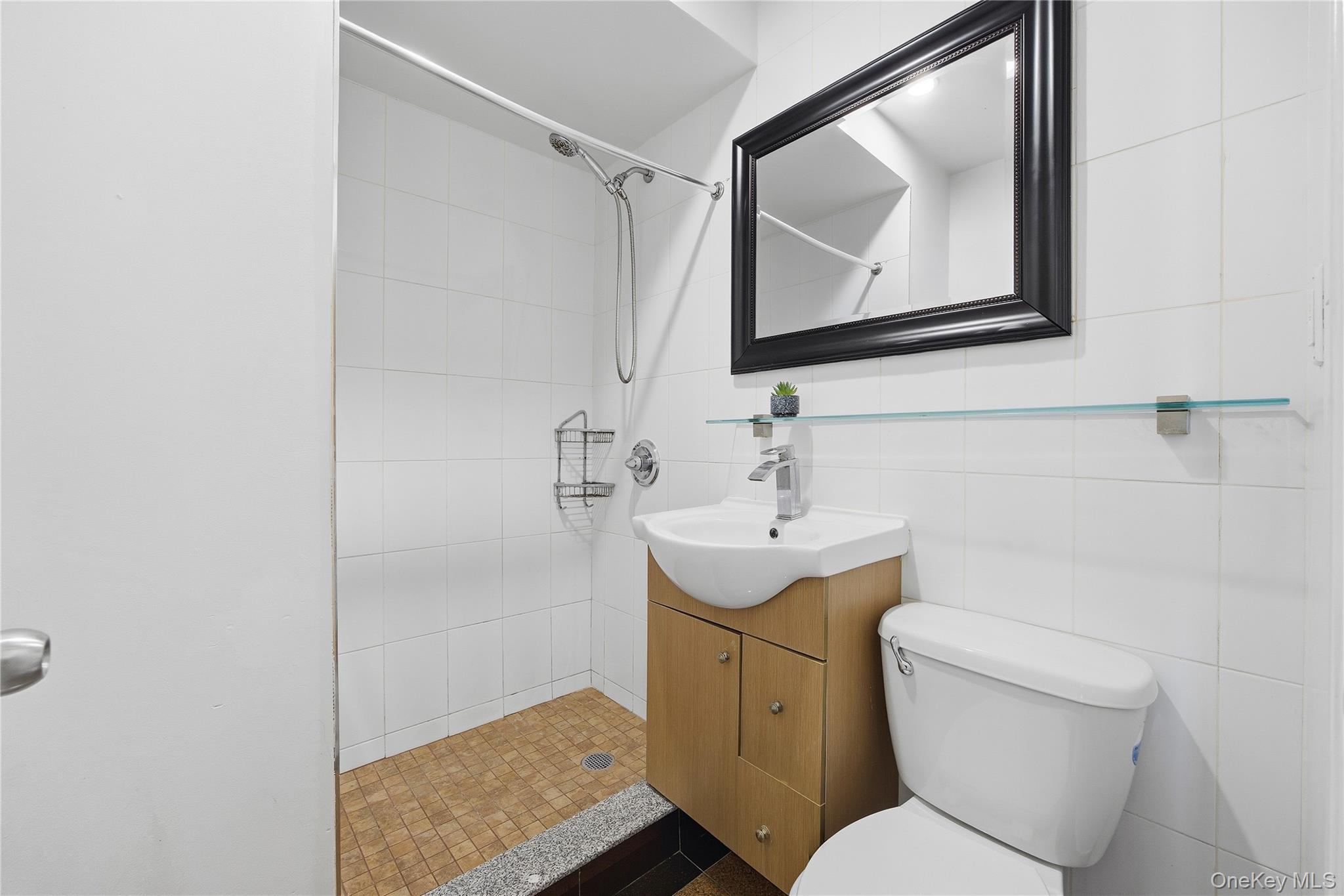106-07 Northern Boulevard, Unit 5B Queens, NY 11368 - Photo 14 of 19 a bathroom with a toilet sink and mirror