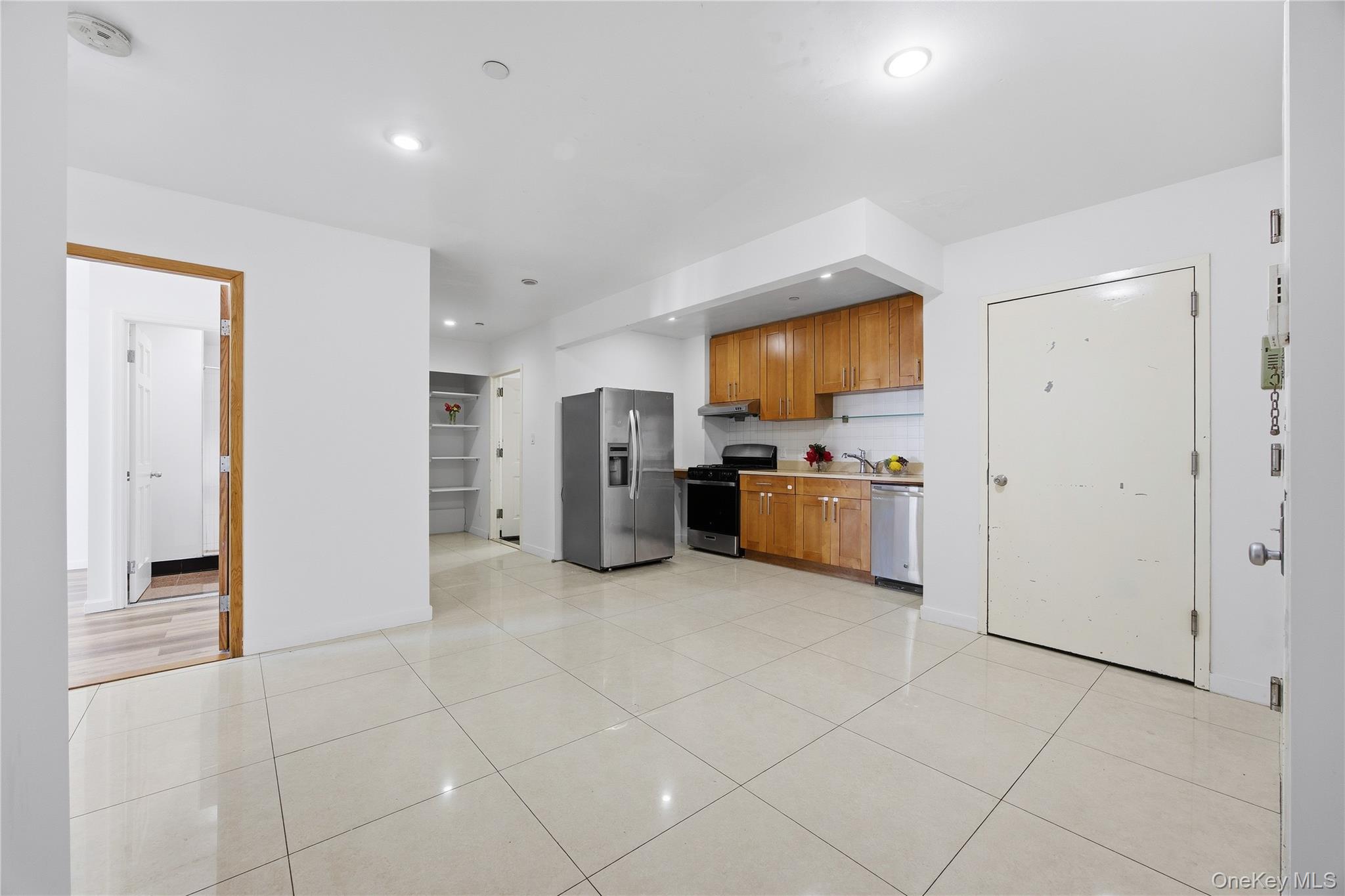 106-07 Northern Boulevard, Unit 5B Queens, NY 11368 - Photo 2 of 19 a kitchen with stainless steel appliances a refrigerator and a stove top oven
