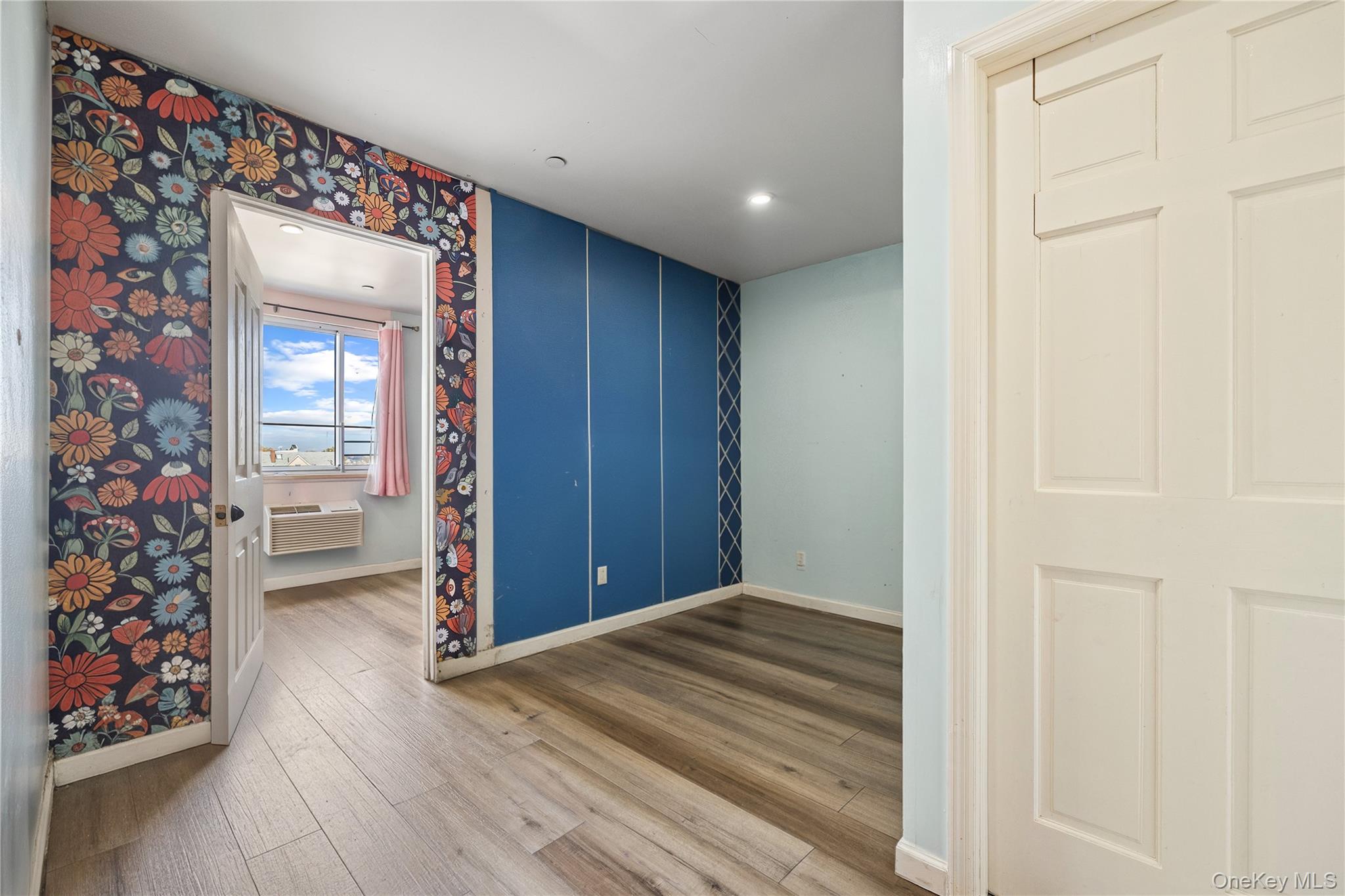 106-07 Northern Boulevard, Unit 5B Queens, NY 11368 - Photo 7 of 18 a view of a hallway with wooden floor and closet